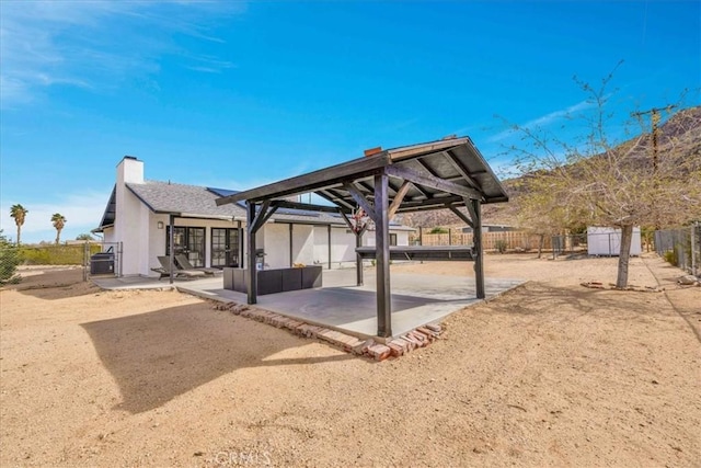 exterior space with a gazebo, a patio, a chimney, and fence