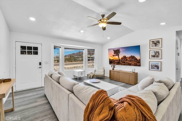 living area featuring light wood finished floors, recessed lighting, and vaulted ceiling