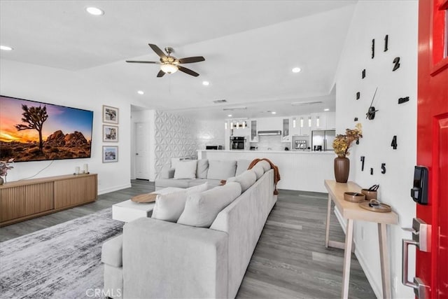 living area with lofted ceiling, recessed lighting, wood finished floors, and ceiling fan