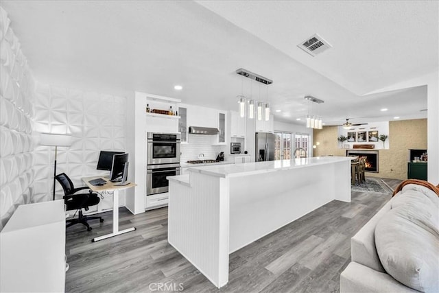 7068 Eucalyptus Ave Unit 29, Palms, CA 92277 - kitchen featuring appliances with stainless steel finishes, open floor plan, white cabinets, light countertops, and wood finished floors
