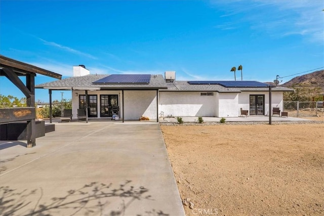 7068 Eucalyptus Ave Unit 29, Palms, CA 92277 - rear view of house featuring french doors, a patio area, and roof mounted solar panels