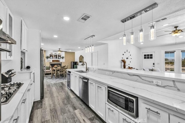 7068 Eucalyptus Ave Unit 29, Palms, CA 92277 - kitchen with a ceiling fan, stainless steel appliances, white cabinets, recessed lighting, and a textured ceiling