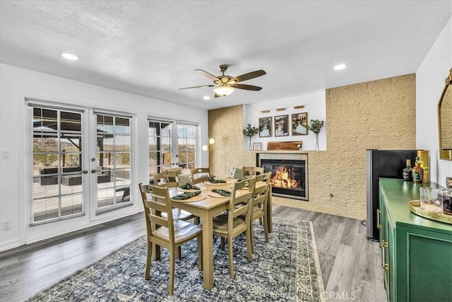 7068 Eucalyptus Ave Unit 29, Palms, CA 92277 - dining area with a fireplace, french doors, a ceiling fan, light wood-style flooring, and recessed lighting