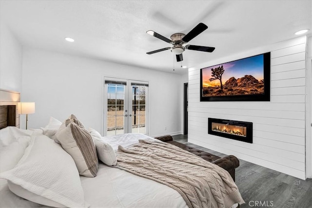 bedroom featuring a large fireplace, recessed lighting, french doors, wood finished floors, and access to outside