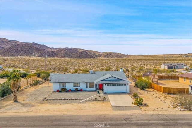 single story home with a mountain view, driveway, an attached garage, and fence