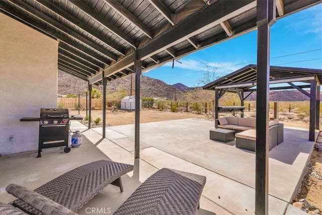 view of patio featuring an outdoor living space, a fenced backyard, a gazebo, grilling area, and a mountain view