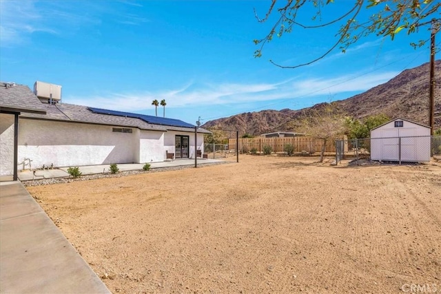 7068 Eucalyptus Ave Unit 29, Palms, CA 92277 - fenced backyard with a patio, a mountain view, a storage shed, and an outdoor structure