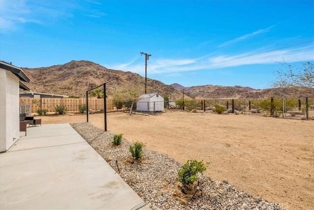 view of yard featuring a patio, a fenced backyard, and a mountain view