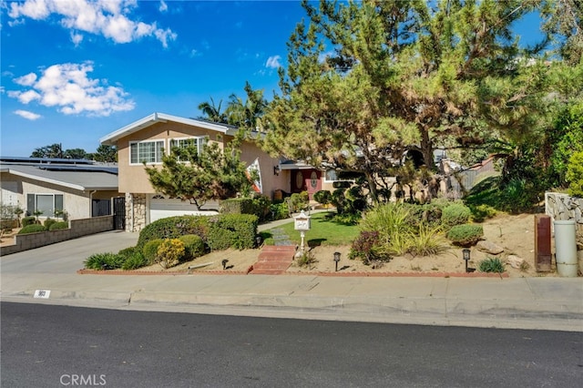 view of front of property featuring an attached garage, driveway, and stucco siding