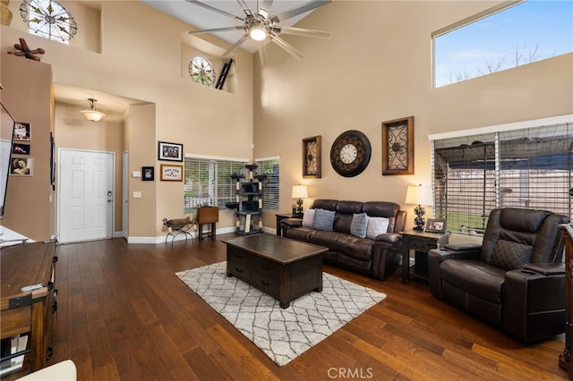 living area with dark wood-style floors, baseboards, a wealth of natural light, and ceiling fan