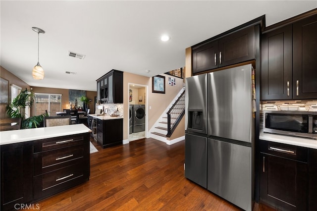 kitchen with visible vents, dark wood-style flooring, light countertops, appliances with stainless steel finishes, and washer and clothes dryer