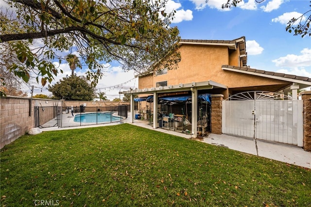 rear view of property with stucco siding, a lawn, a gate, a fenced backyard, and a fenced in pool