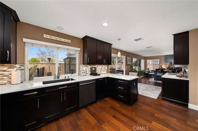 kitchen featuring visible vents, open floor plan, dishwasher, light countertops, and a sink