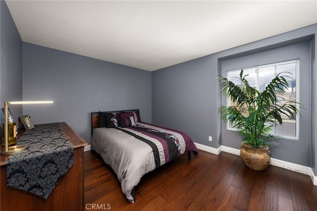 bedroom featuring baseboards and wood-type flooring