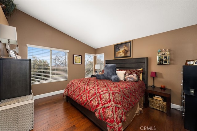 bedroom featuring baseboards, lofted ceiling, and wood finished floors