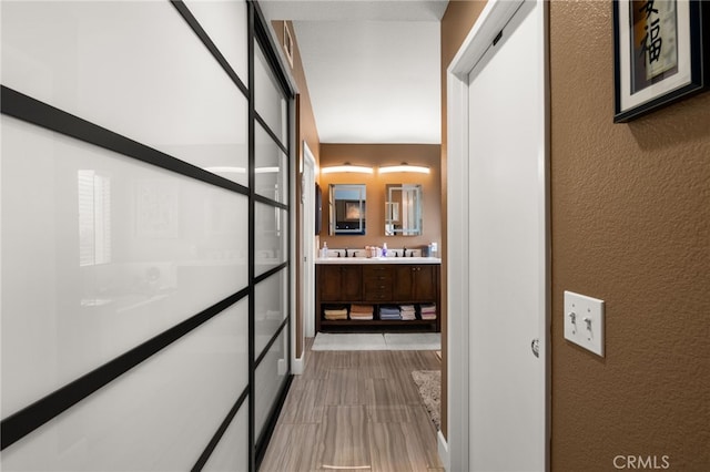 hallway featuring a sink and a textured wall