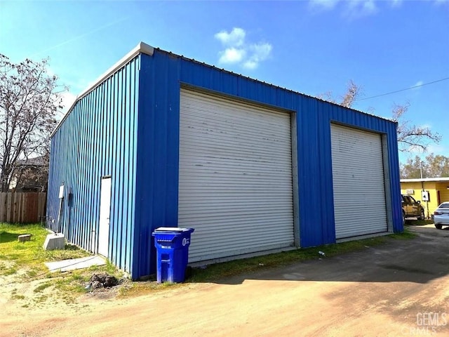 detached garage featuring fence