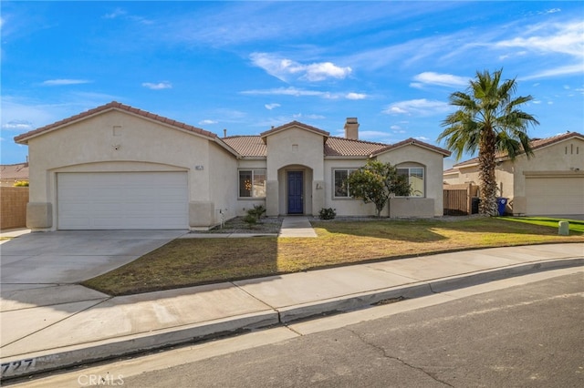 mediterranean / spanish home featuring stucco siding, a front lawn, driveway, a garage, and a tiled roof