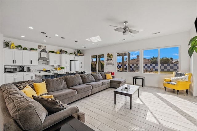 living area with visible vents, baseboards, recessed lighting, light wood-style flooring, and a ceiling fan