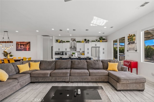 living room featuring recessed lighting, light wood-style floors, visible vents, and baseboards