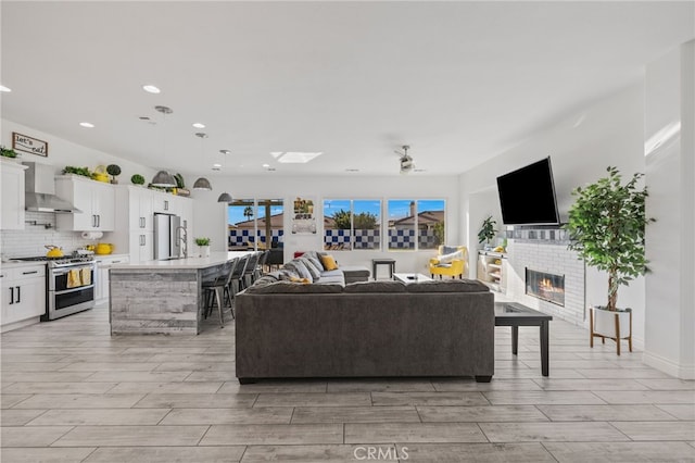 living room with a glass covered fireplace, recessed lighting, and wood finish floors