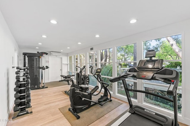 workout area featuring light wood-style flooring and recessed lighting