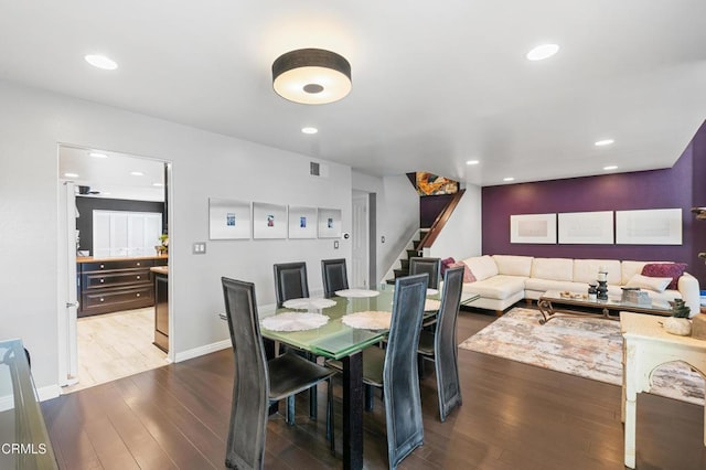 dining area featuring visible vents, recessed lighting, stairs, and wood finished floors