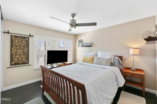 bedroom with ceiling fan, baseboards, and wood finished floors