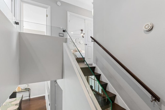 staircase with baseboards and wood finished floors