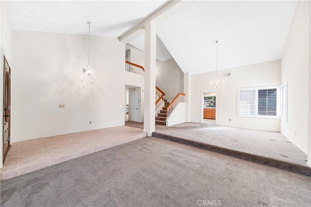 unfurnished living room with visible vents, carpet floors, a chandelier, and stairs