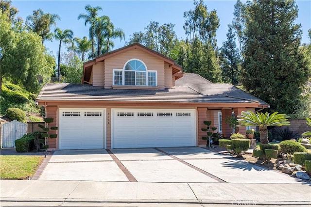 traditional-style house with a tiled roof, driveway, a garage, and fence