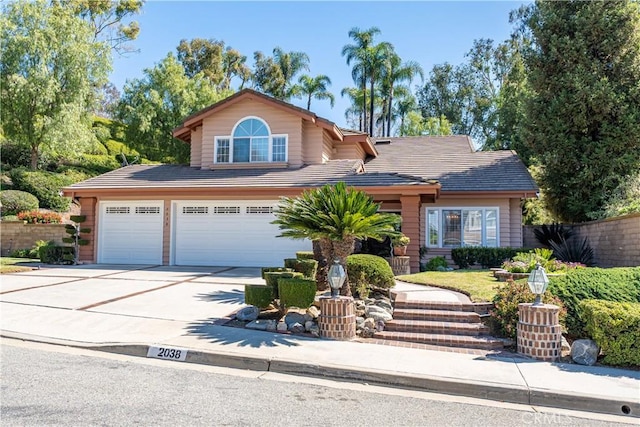 view of front of property with fence, concrete driveway, and a tiled roof