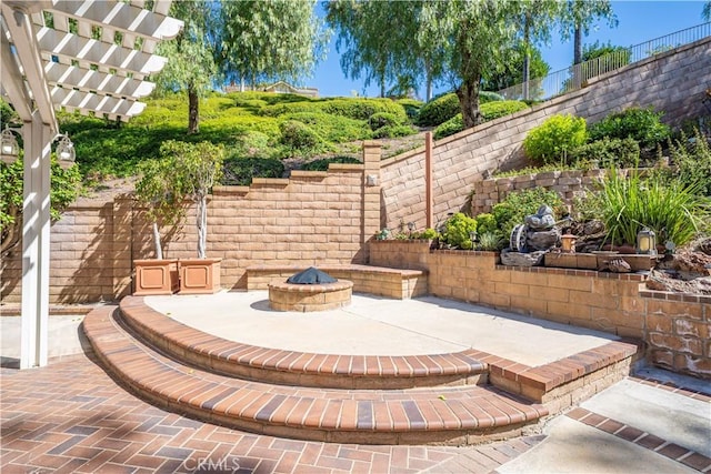 view of patio / terrace featuring fence, a pergola, and an outdoor fire pit