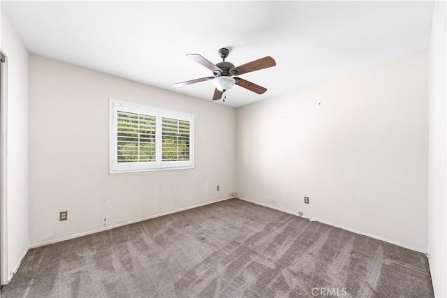 carpeted spare room featuring a ceiling fan