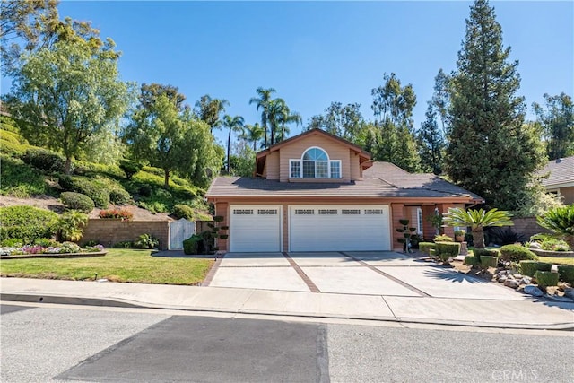 traditional-style house featuring concrete driveway, a front lawn, and fence