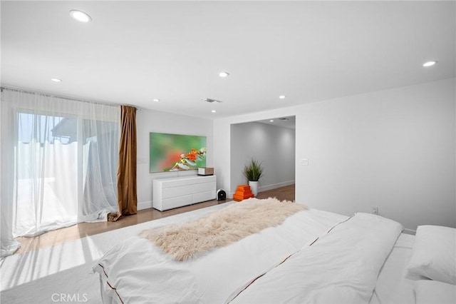 bedroom with recessed lighting, visible vents, baseboards, and wood finished floors