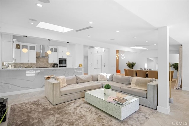 living area featuring recessed lighting, baseboards, marble finish floor, and a skylight