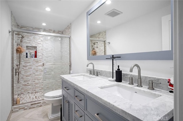 full bath with a sink, visible vents, a shower stall, and double vanity