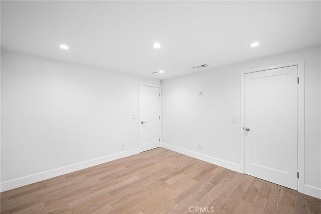 spare room featuring recessed lighting, light wood-style floors, visible vents, and baseboards