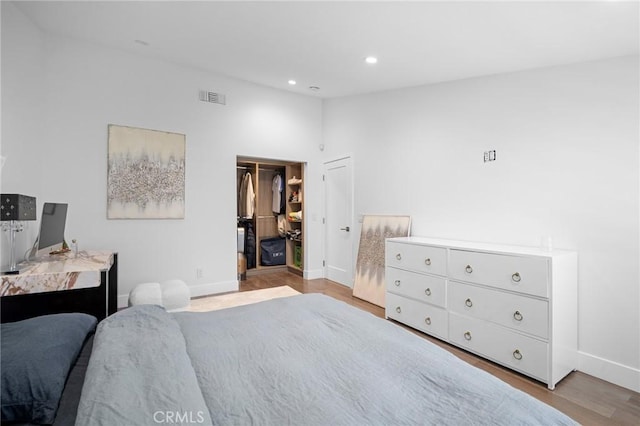 bedroom featuring visible vents, lofted ceiling, wood finished floors, recessed lighting, and baseboards