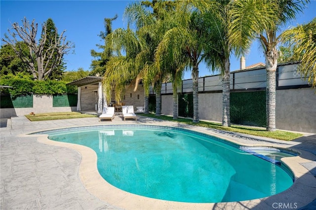 view of pool featuring a patio area, a pool with connected hot tub, and fence