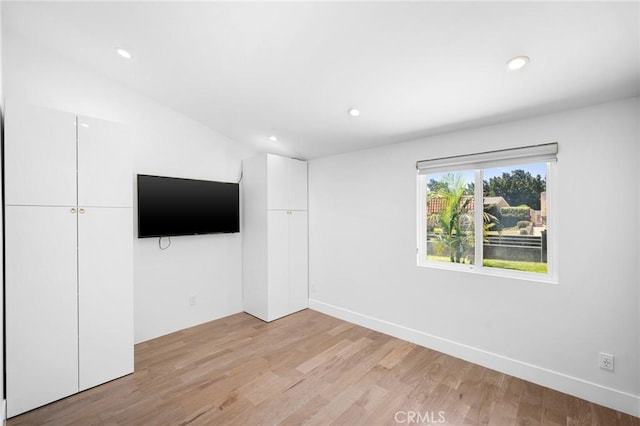 unfurnished living room featuring light wood finished floors, recessed lighting, and baseboards