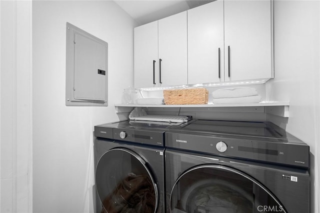 washroom featuring electric panel, cabinet space, and washer and dryer