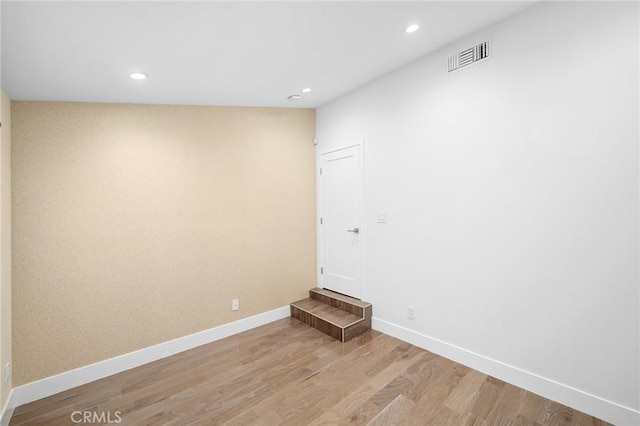 spare room with recessed lighting, visible vents, light wood-style flooring, and baseboards