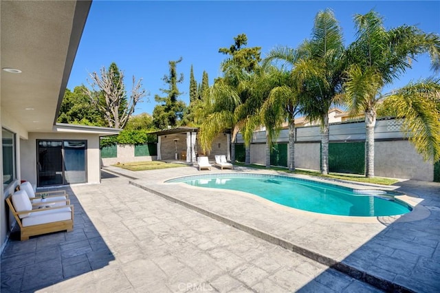 outdoor pool with a patio area and fence