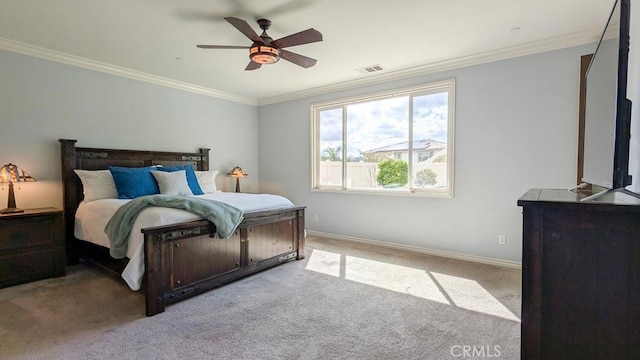 carpeted bedroom featuring visible vents, baseboards, a ceiling fan, and crown molding