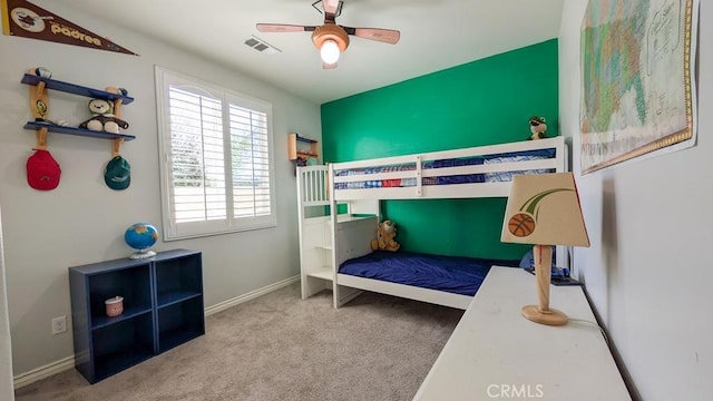 carpeted bedroom with visible vents, baseboards, and a ceiling fan