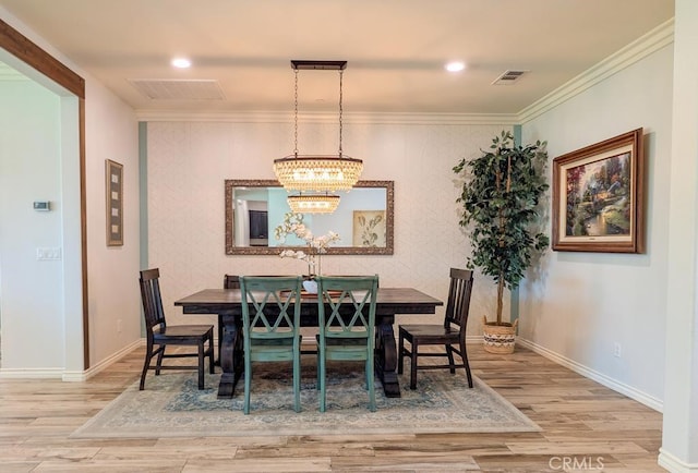 dining space with visible vents, baseboards, wood finished floors, and an accent wall