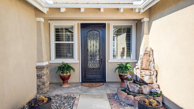 view of exterior entry with stucco siding