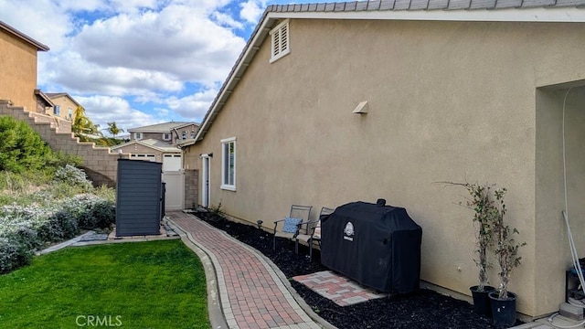 view of side of property with stucco siding and a lawn